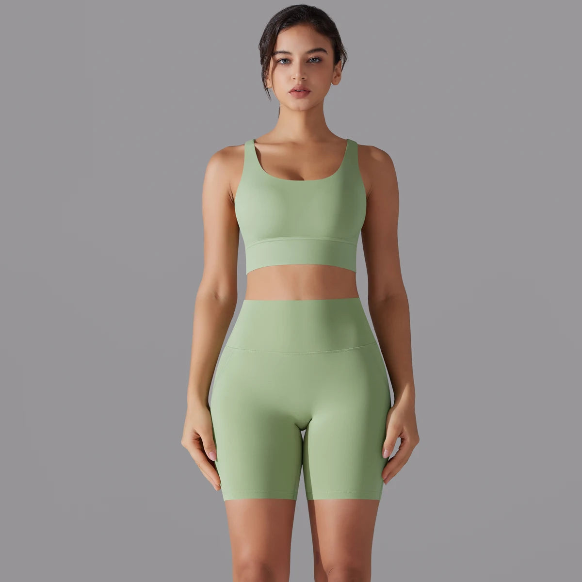 Nahtloses Fitnessset für Damen: grünes Sporttop und kurze Leggings im Set-Look