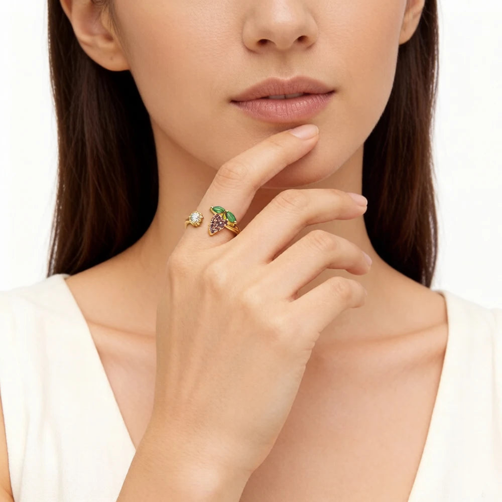 Ring am Finger: goldfarbener Schmuck mit Grünstein und violetten Traubensteinen