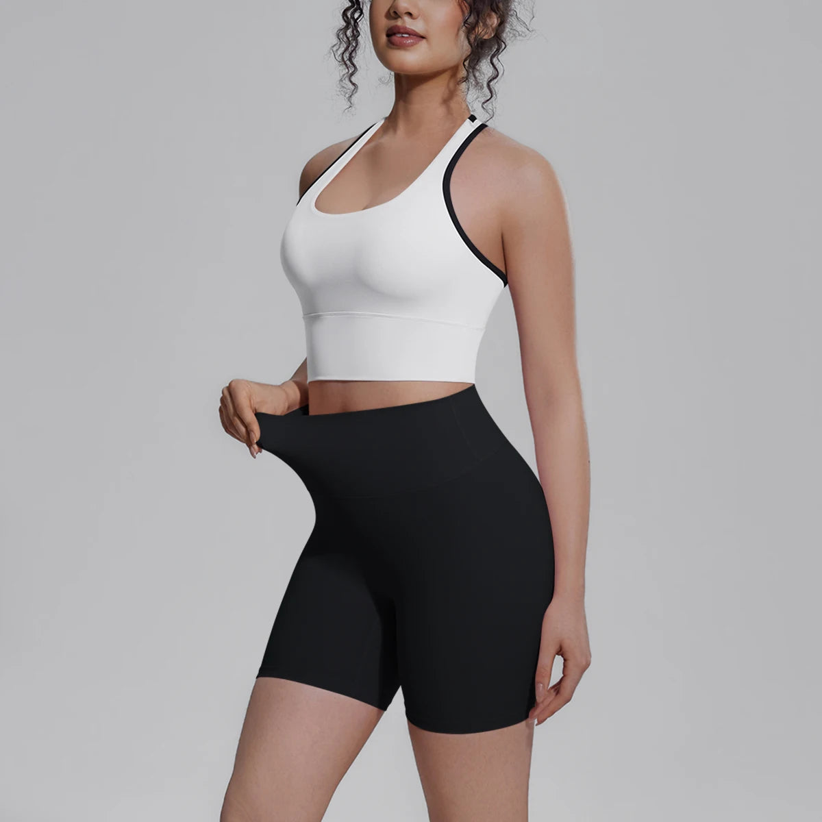 Yoga-Set für Damen seitlich: weißes Träger-Top und schwarze High-Waist-Shorts
