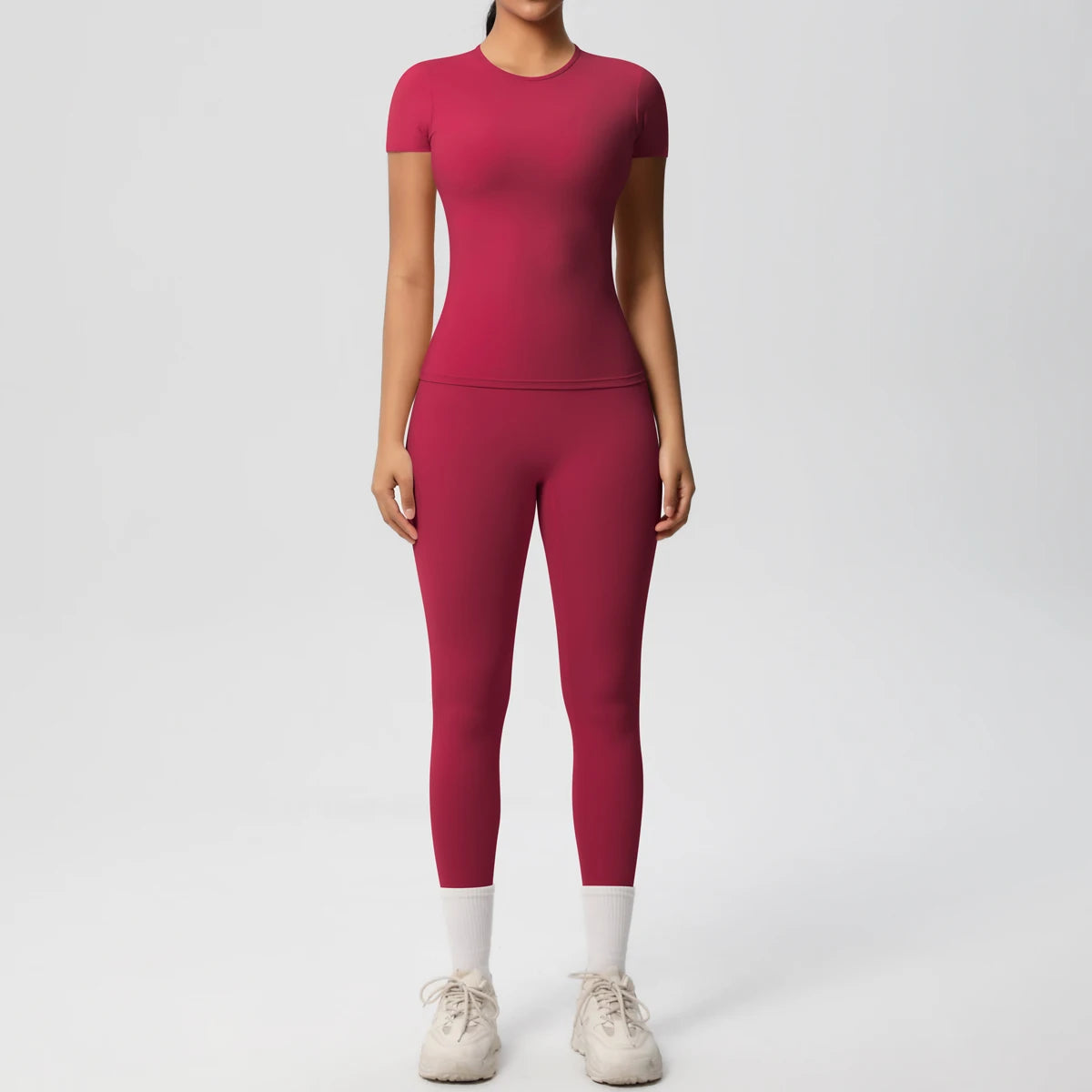 Bordeauxrotes Sport-Set aus Crop-Top und Leggings, eng anliegend, 3/4-Länge, weißer Abschluss.