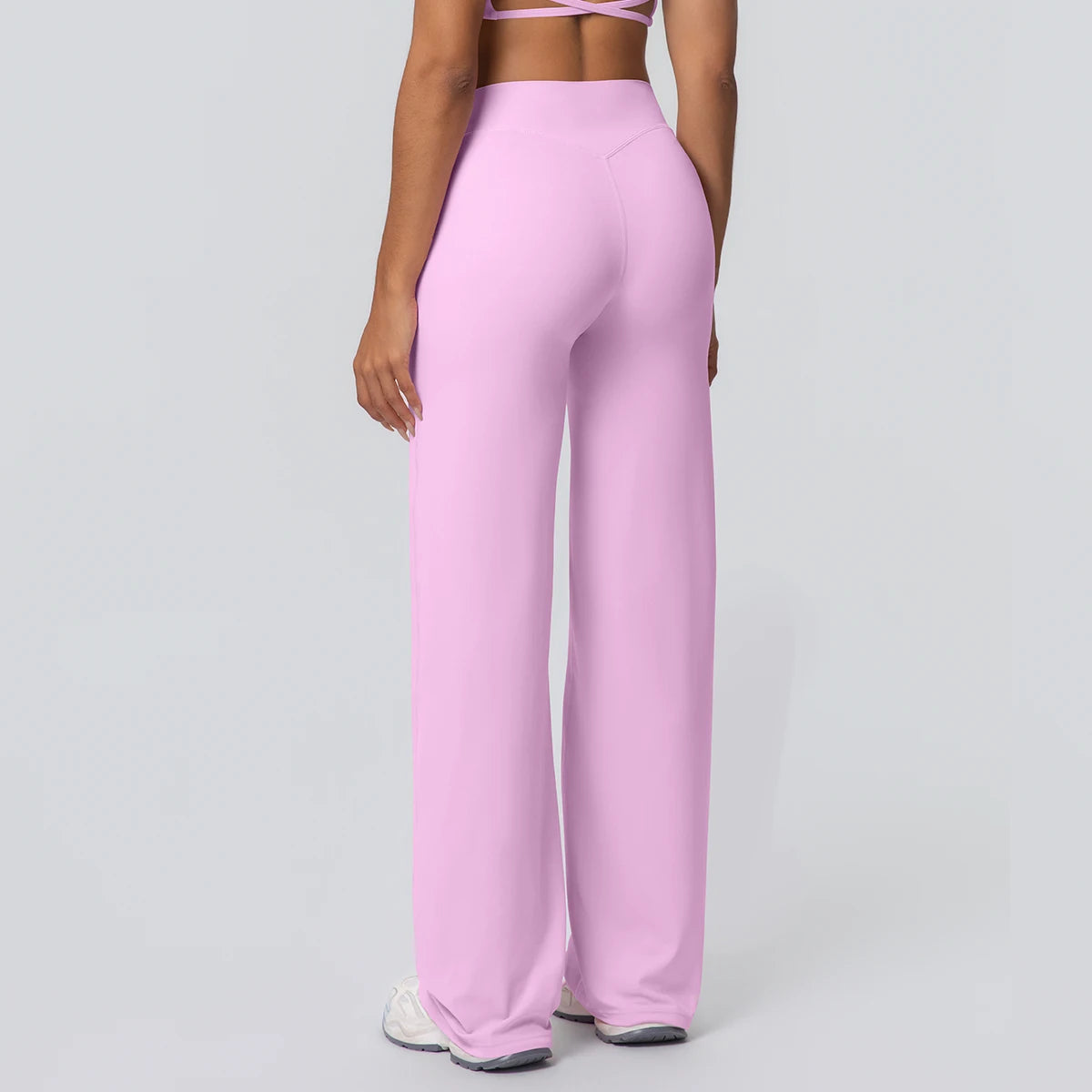 Weite Yoga-Hose in hellem Rosa, hohe Taille, langer Beinverlauf, seitlich fließend.