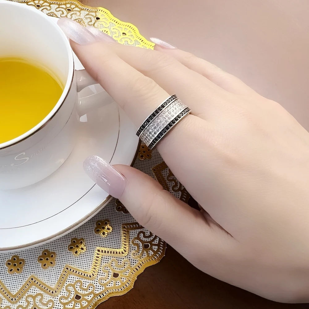 Ring am Finger: breites 925-Silberband mit schwarzer Einfassung und weißem Pavé