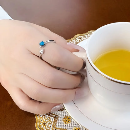 Silberner Ring mit türkisblauem Stein auf der Hand, verziert mit Zirkonia
