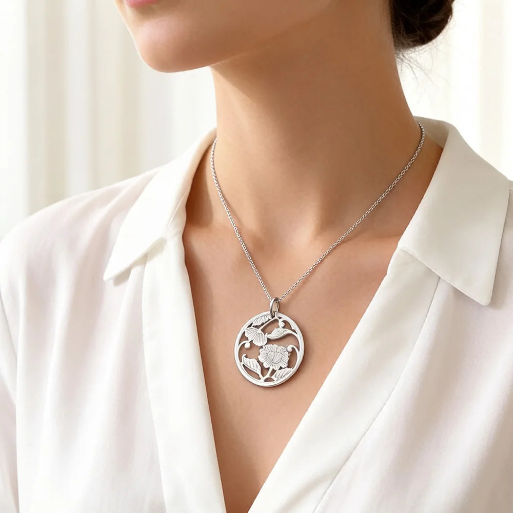 Silberfarbener Anhänger mit Blumenrelief an feiner Kette, runde Form