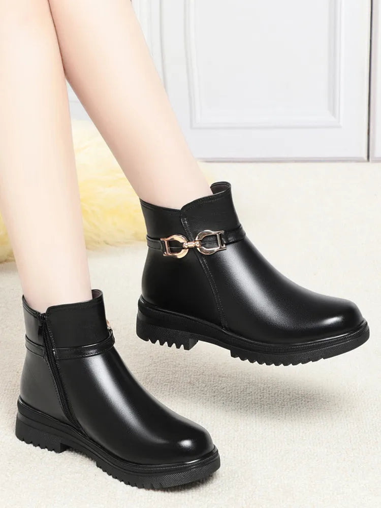 Paar schwarze Winterstiefel mit Schnallenriemen und flacher, profilierter Sohle