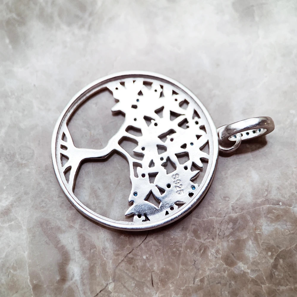 Silberfarbener Anhänger mit Baum-Silhouette im Kreis und seitlicher Öse