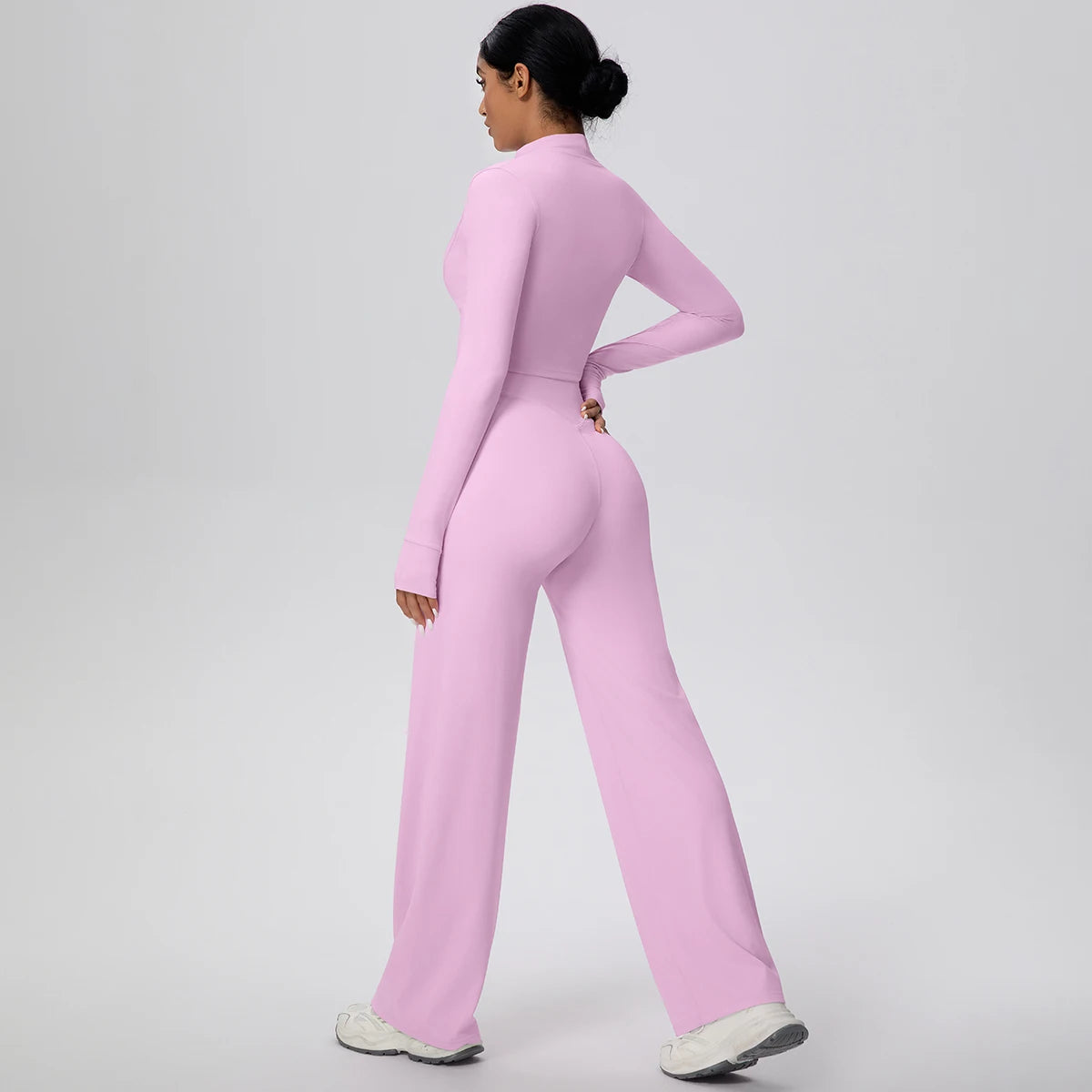 Rosa Yoga-Set mit Reißverschluss-Crop-Top und High-Waist-Hose, seitliche Ansicht.