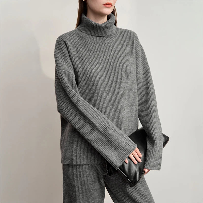 Dunkelgrauer Rollkragenpullover im Rippenstrick-Look, lange Ärmel; schwarze Umhängetasche
