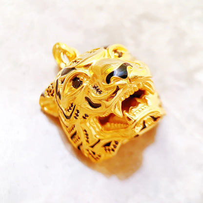 Goldfarbener Tigerkopf-Anhänger als Detailaufnahme mit markanter Prägung