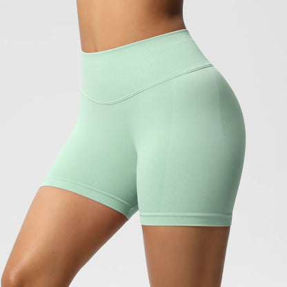 Hohe taillierte Sportshorts, hellgrün, elastischer Stoff, hinten mit Ziernähten.