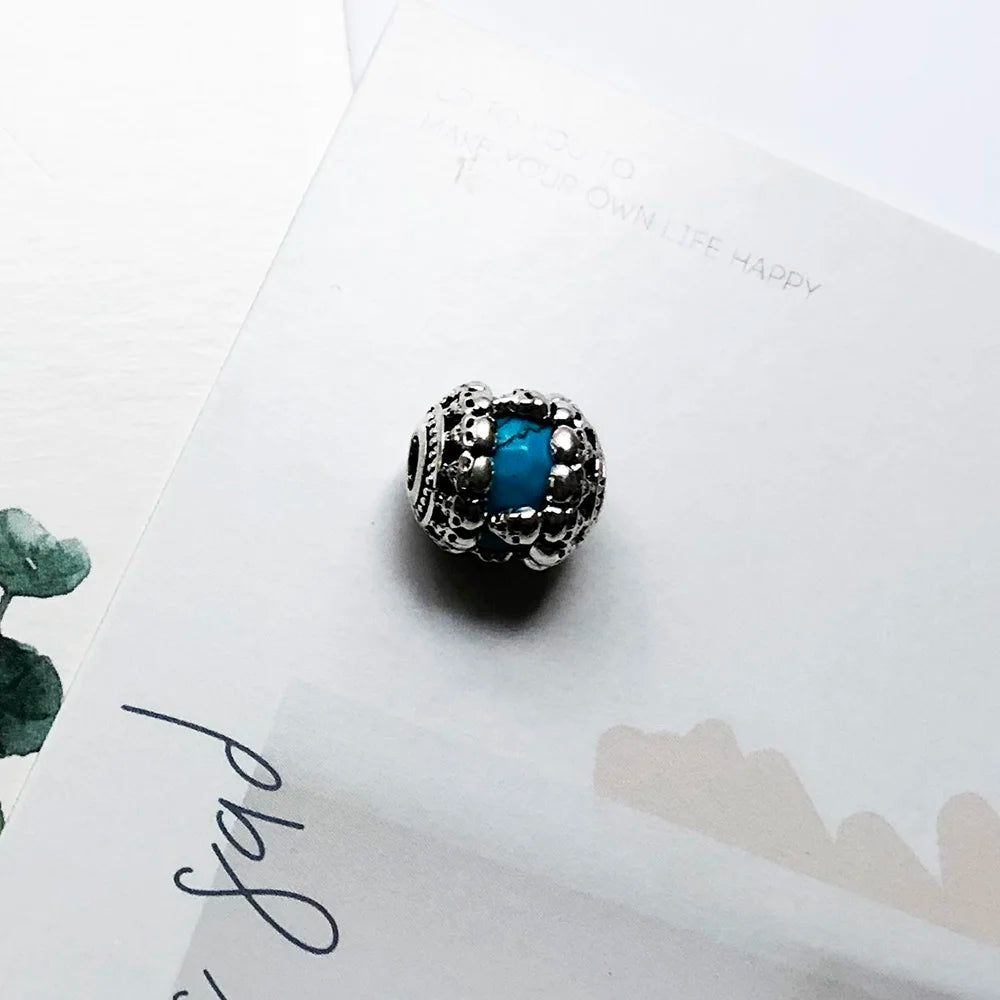 Charmperle mit blauem Stein in silbernem Fassungsdesign