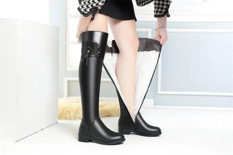 Schwarze Overknee-Stiefel mit Fellfutter innen und funkelnder Zierapplikation am Schaft