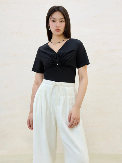 Damen-T-Shirt aus Baumwolle mit V-Ausschnitt und kurzen Ärmeln in vier Farben, mit Falten-Design an der Schulter.