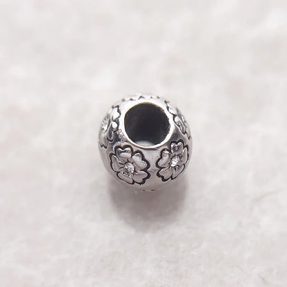 Charm-Perle aus 925er Sterlingsilber mit Blumenrelief und dunklem runden Einsatz