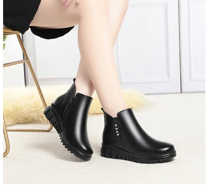Schwarze Stiefeletten mit Innenplüsch am Schaftrand, seitlicher Ziernaht und Profilsohle