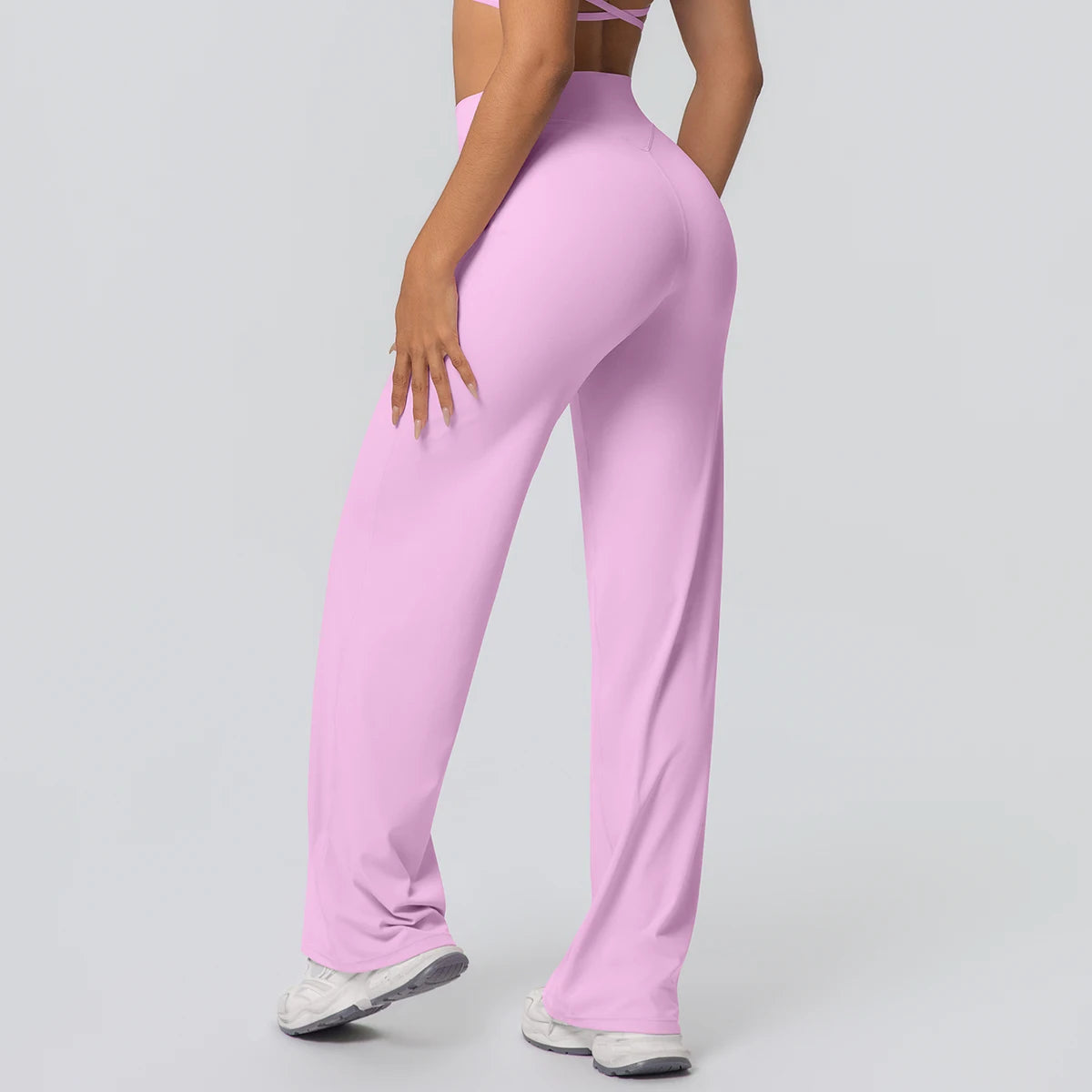 Weite Yoga-Hose in hellem Rosa, Rückansicht mit hoher Taille und weit fallenden Beinen.