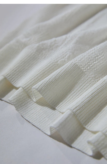 Beiger Strickpullover mit V-Ausschnitt und Halbarm; feines Lochmuster im Detail.
