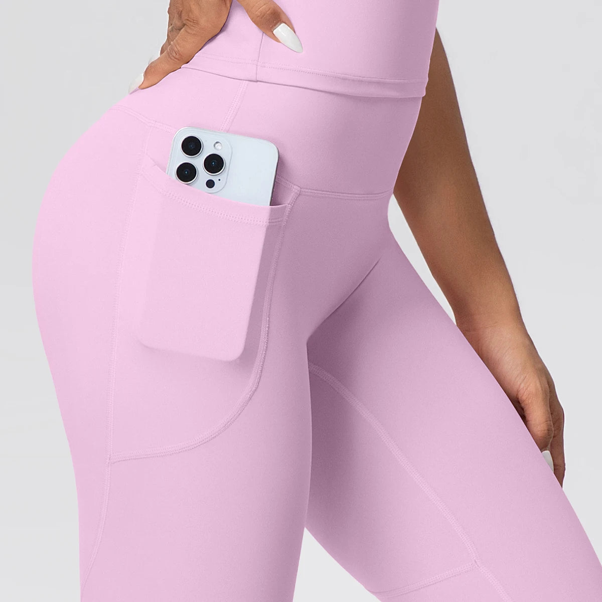Fliederfarbenes Sportoutfit mit Handytasche in der Hüfte der Leggings und Top