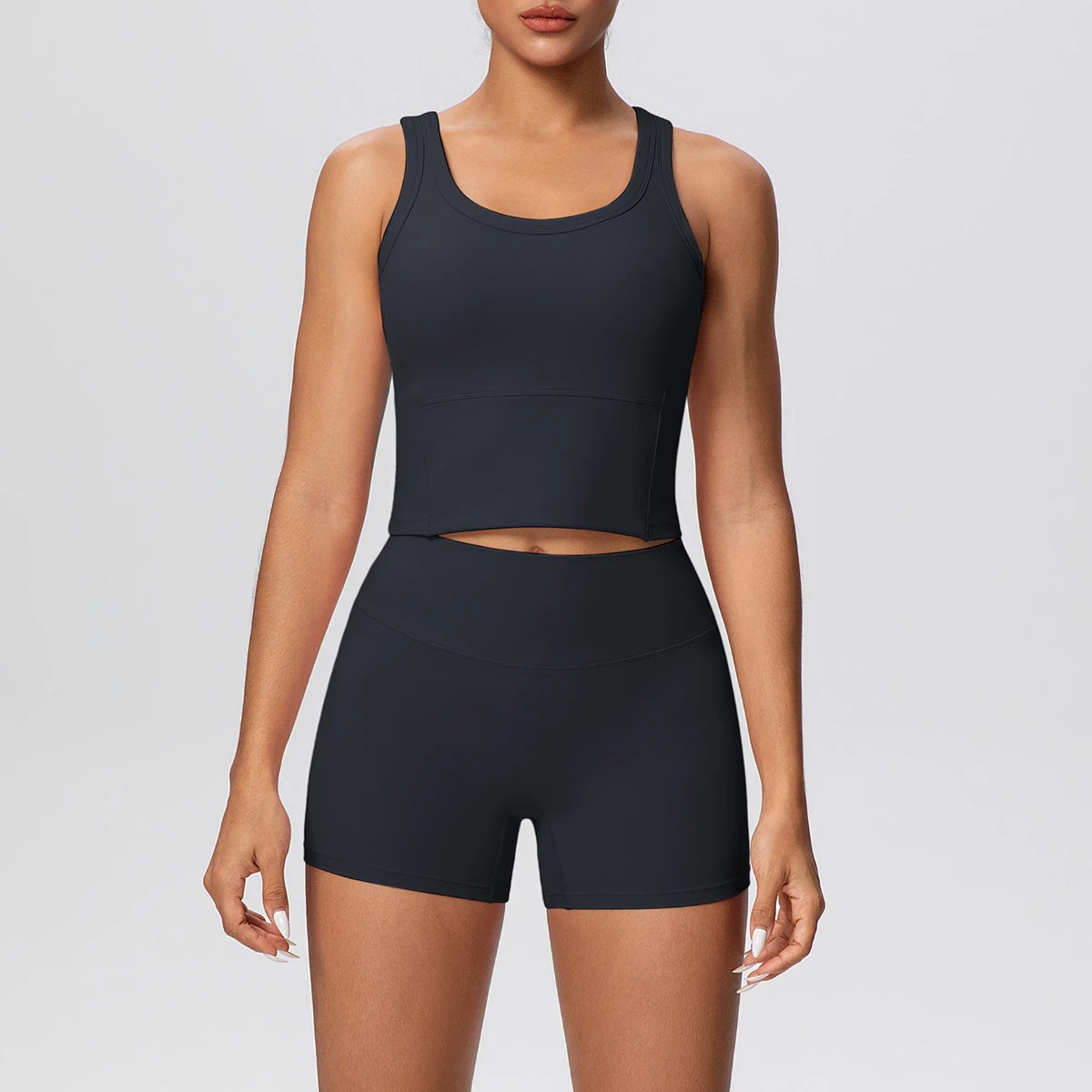 Damen-Yoga-Set in Schwarz: ärmelloses Croptop und kurze Leggings mit Midriff-Ausschnitt.