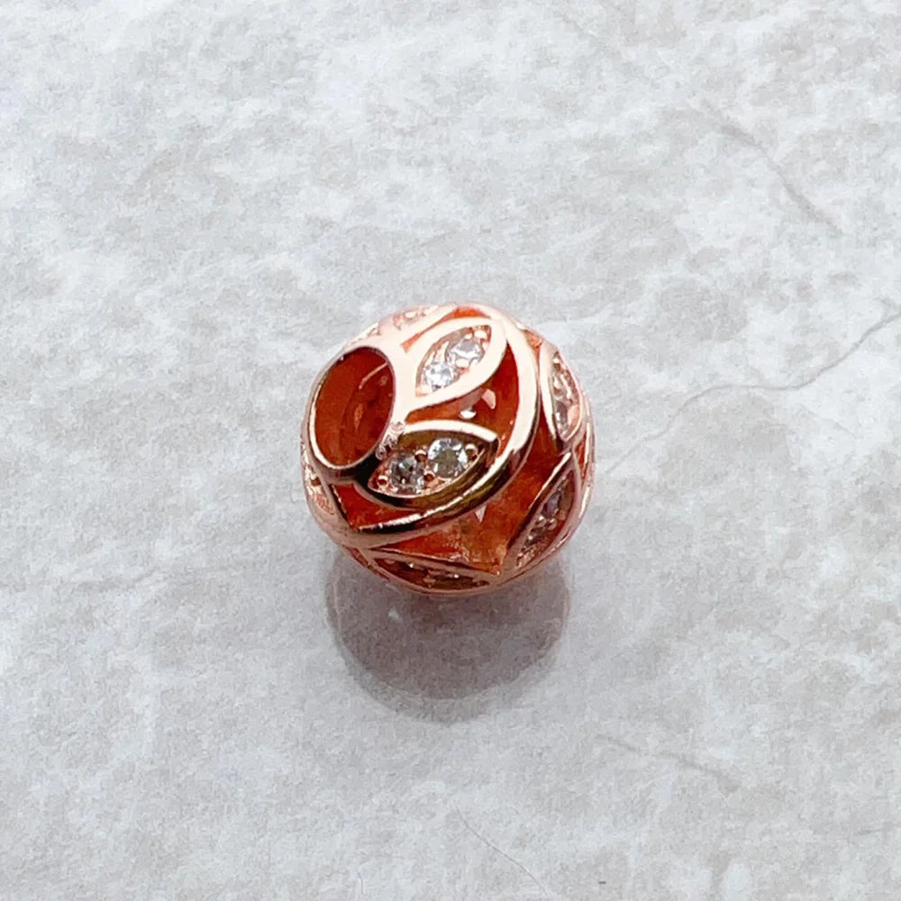 Roségoldener Charm mit rotem Emaille-Motiv und glitzernden Zirkonia-Steinen