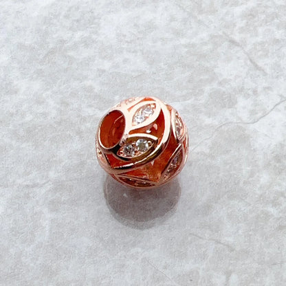 Roségoldener Charm mit rotem Emaille-Motiv und glitzernden Zirkonia-Steinen