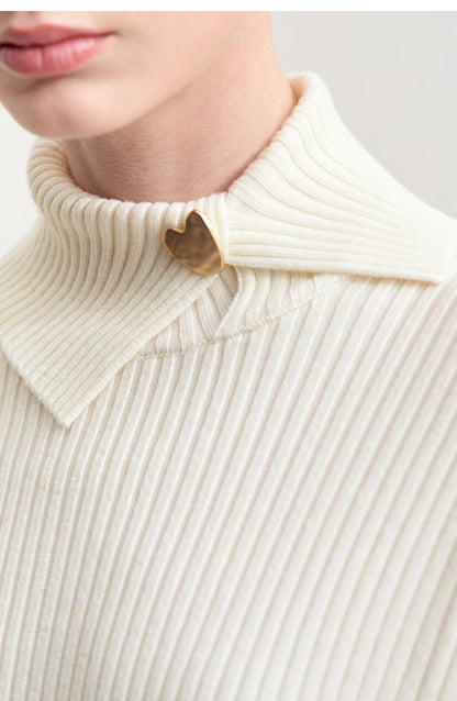 Nahaufnahme Damen-Strickpullover: gerippter Stehkragen und Knopf aus Metall, cremefarben