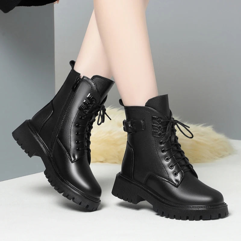 Schwarze Winterstiefel am Bein: Schnürung, seitlicher Riemen und dicke Profilsohle