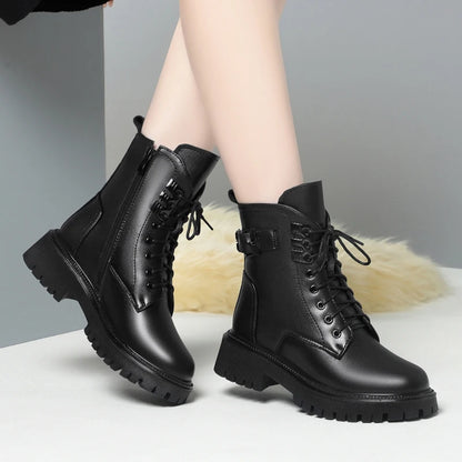 Schwarze Winterstiefel am Bein: Schnürung, seitlicher Riemen und dicke Profilsohle