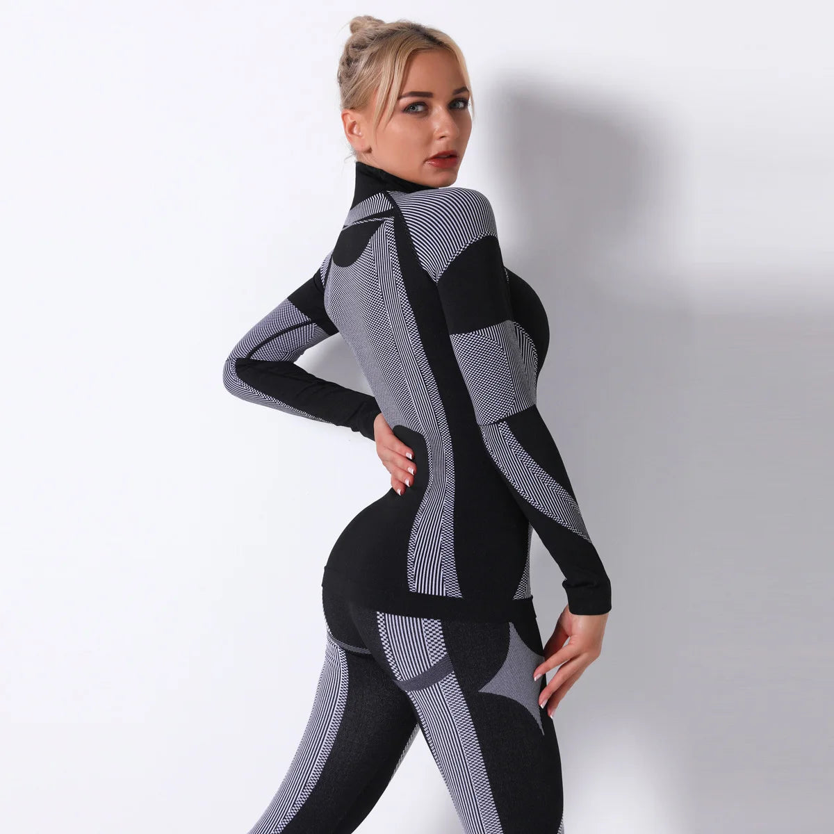 Nahtloses Sportoberteil für Damen in Schwarz mit grauen Kontraststreifen, hochgeschlossen, Langarm.