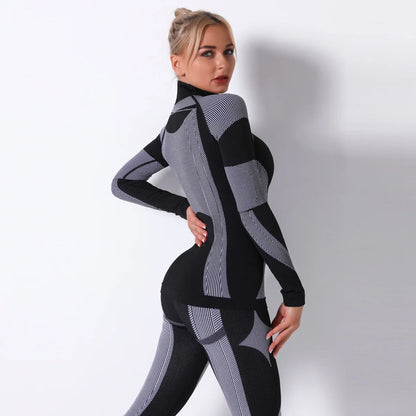 Nahtloses Sportoberteil für Damen in Schwarz mit grauen Kontraststreifen, hochgeschlossen, Langarm.