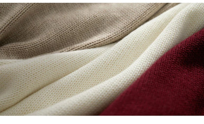 Strickpullover-Detail: beigefarbene Rippenstruktur neben Burgunderfarbe