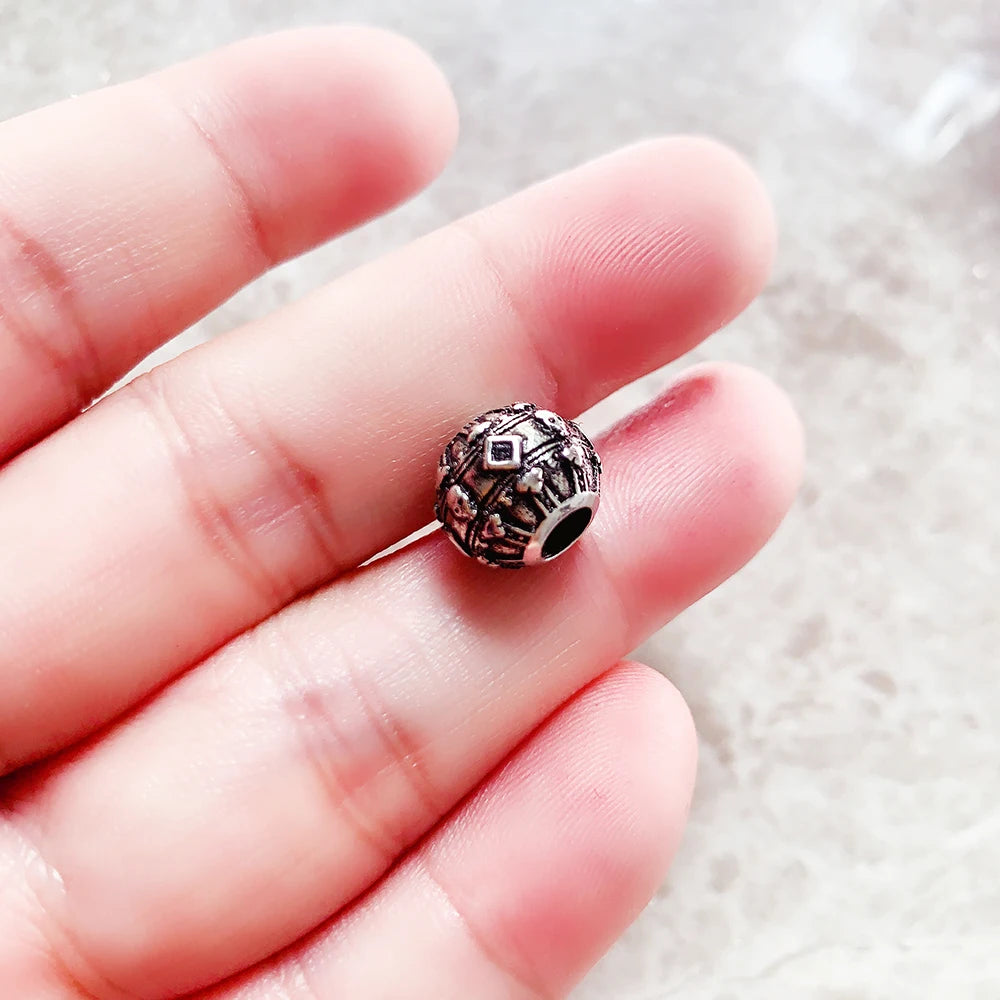 In der Hand gehaltene 925-Silber-Charmeperle mit Krone und Totenkopf, rund
