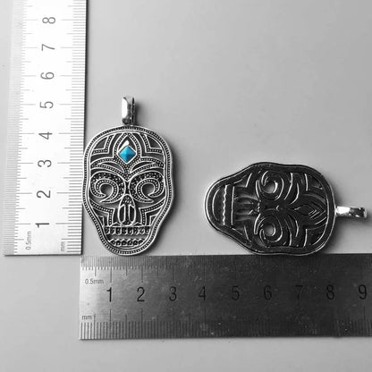 Totenkopf-Anhänger in Sterlingsilber mit blauem Cabochon, neben Größenlineal