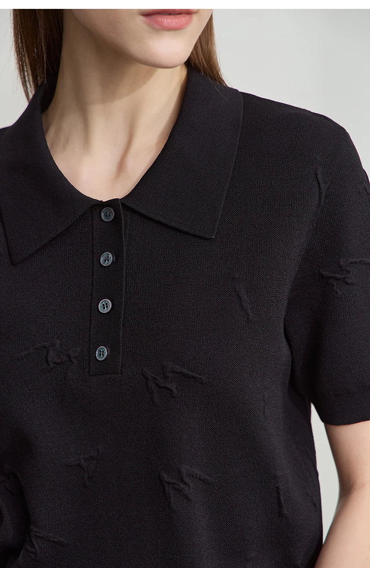 Detailansicht: schwarzer Strickpullover mit Polo-Kragen und Knopfleiste, feine Stickerei