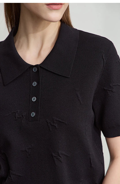 Detailansicht: schwarzer Strickpullover mit Polo-Kragen und Knopfleiste, feine Stickerei