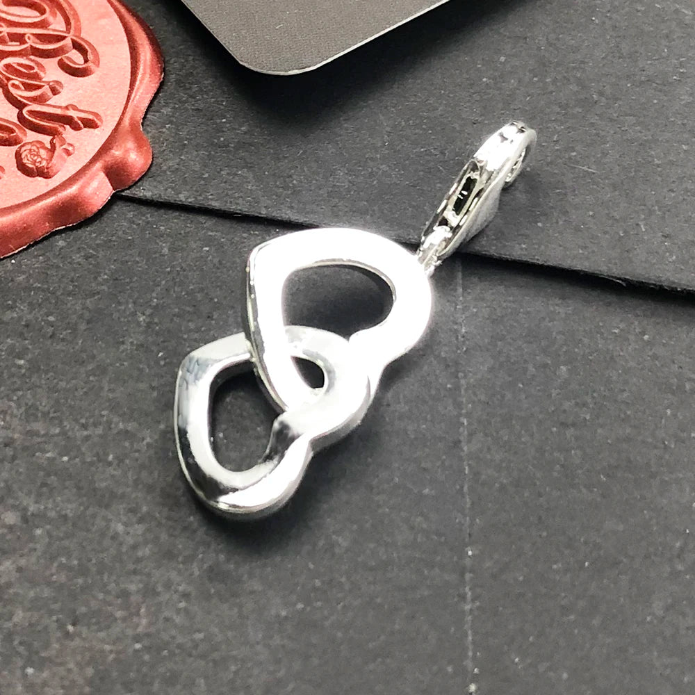 Nahaufnahme: Herz-Charm-Anhänger aus 925 Sterlingsilber mit ineinander verschlungenem Herzen
