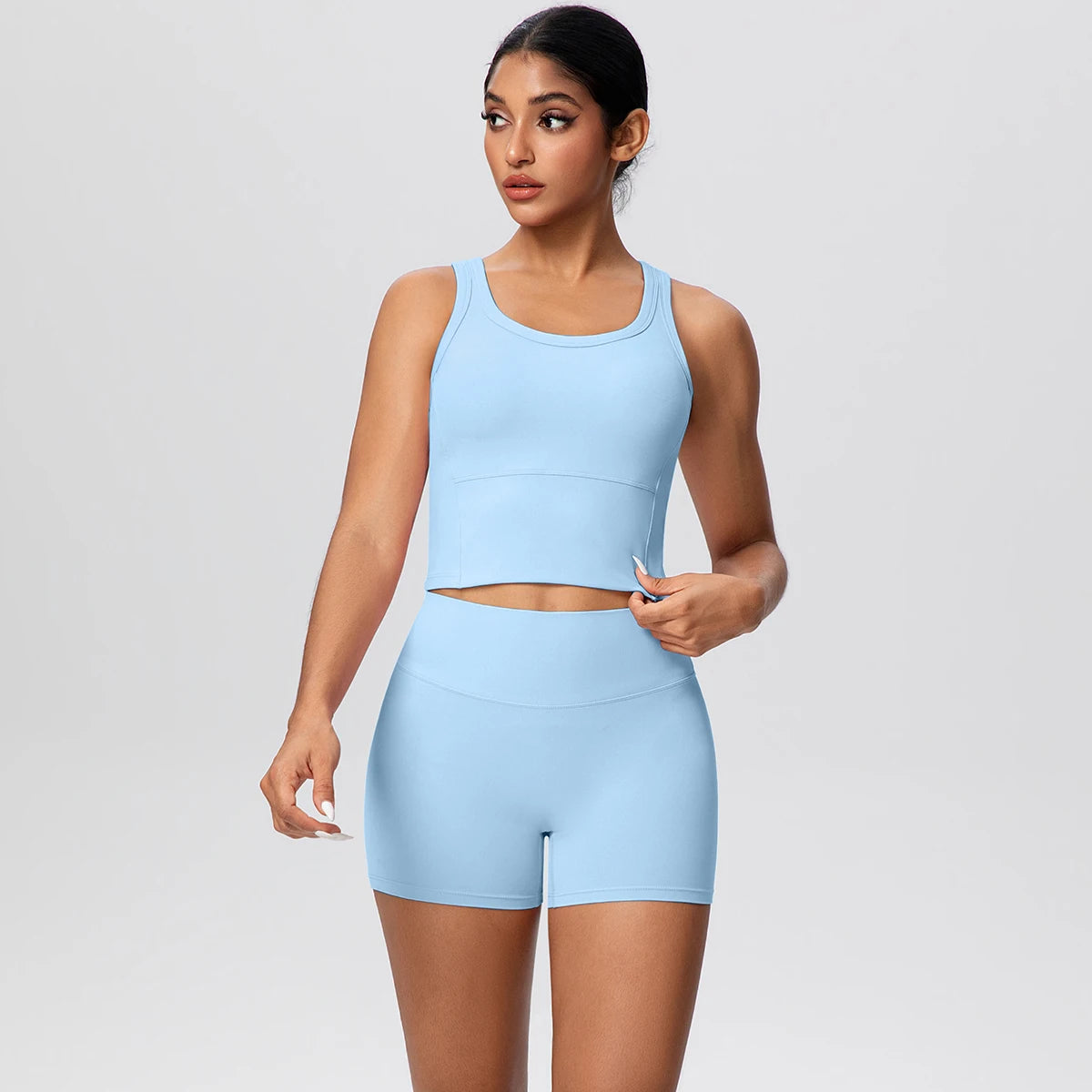 Damen-Yoga-Set in Hellblau: Croptop ohne Ärmel und kurze Leggings mit Bund-Abdeckung.
