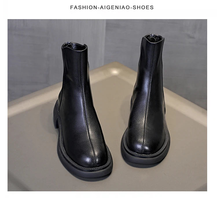 Schwarze Leder-Stiefeletten mit Chelsea-Optik und flacher Profilsohle, Frontansicht von vorn.
