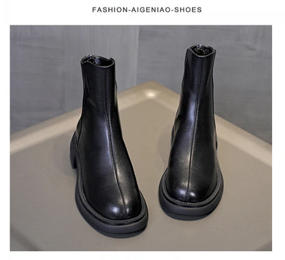 Schwarze Leder-Stiefeletten mit Chelsea-Optik und flacher Profilsohle, Frontansicht von vorn.