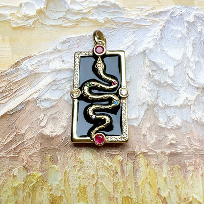 Schlangen-Anhänger mit schwarzem Rechteck und goldfarbener Einfassung, mit rosa Steinen
