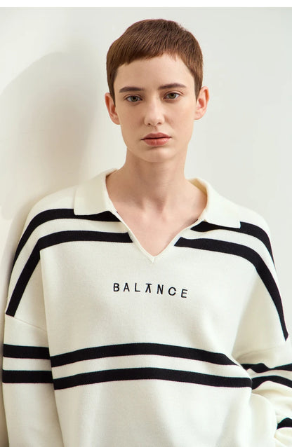 Nahansicht: Cremefarbener Pullover mit schwarzen Streifen und „BALANCE“