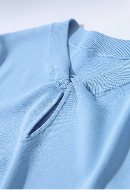 Detailansicht Vorderseite: hellblaues Stricktop mit Knopföffnung am Halsausschnitt