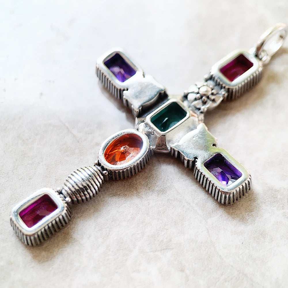 Kreuz-Anhänger Nahaufnahme, silberfarben, mit violetten, grünen und orangen Steinen