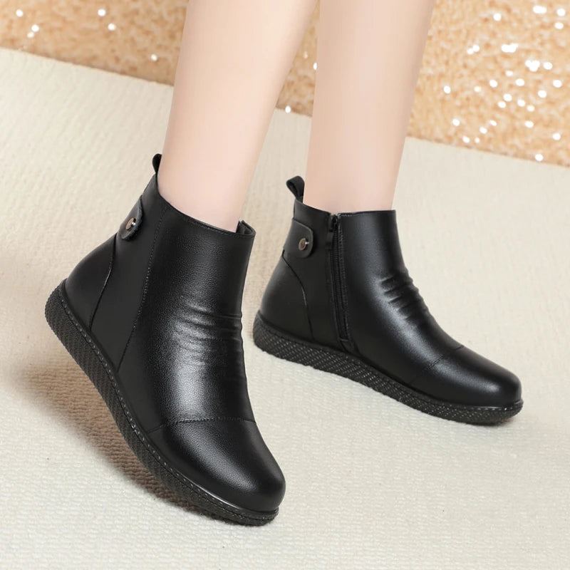 Zwei schwarze Stiefeletten nebeneinander, flache rutschfeste Profilsohle