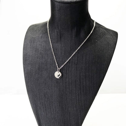 Herz-Anhänger aus Silber an Kette auf Schmuckständer, rundes Medaillon mit Herzmotiv