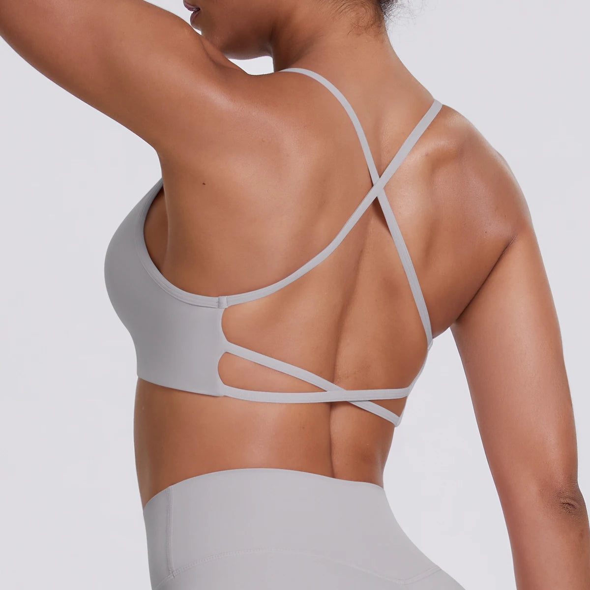 Hellgraues Sport-Crop-Top, Rückansicht mit gekreuzten Trägern und Aussparung