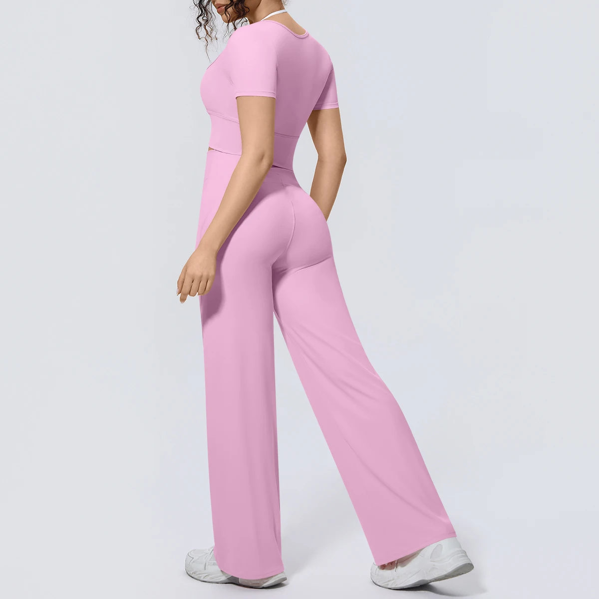 Rosa Yoga-Set mit kurzem Oberteil und weiter Hose, seitliche Ansicht
