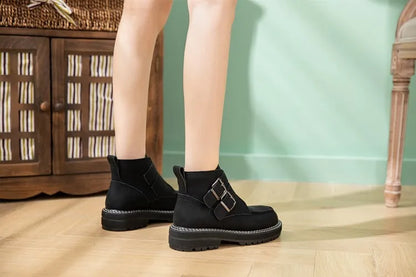 AIYUQI schwarze Stiefeletten mit Schnallenriemen und Profilsohle, seitlich getragen