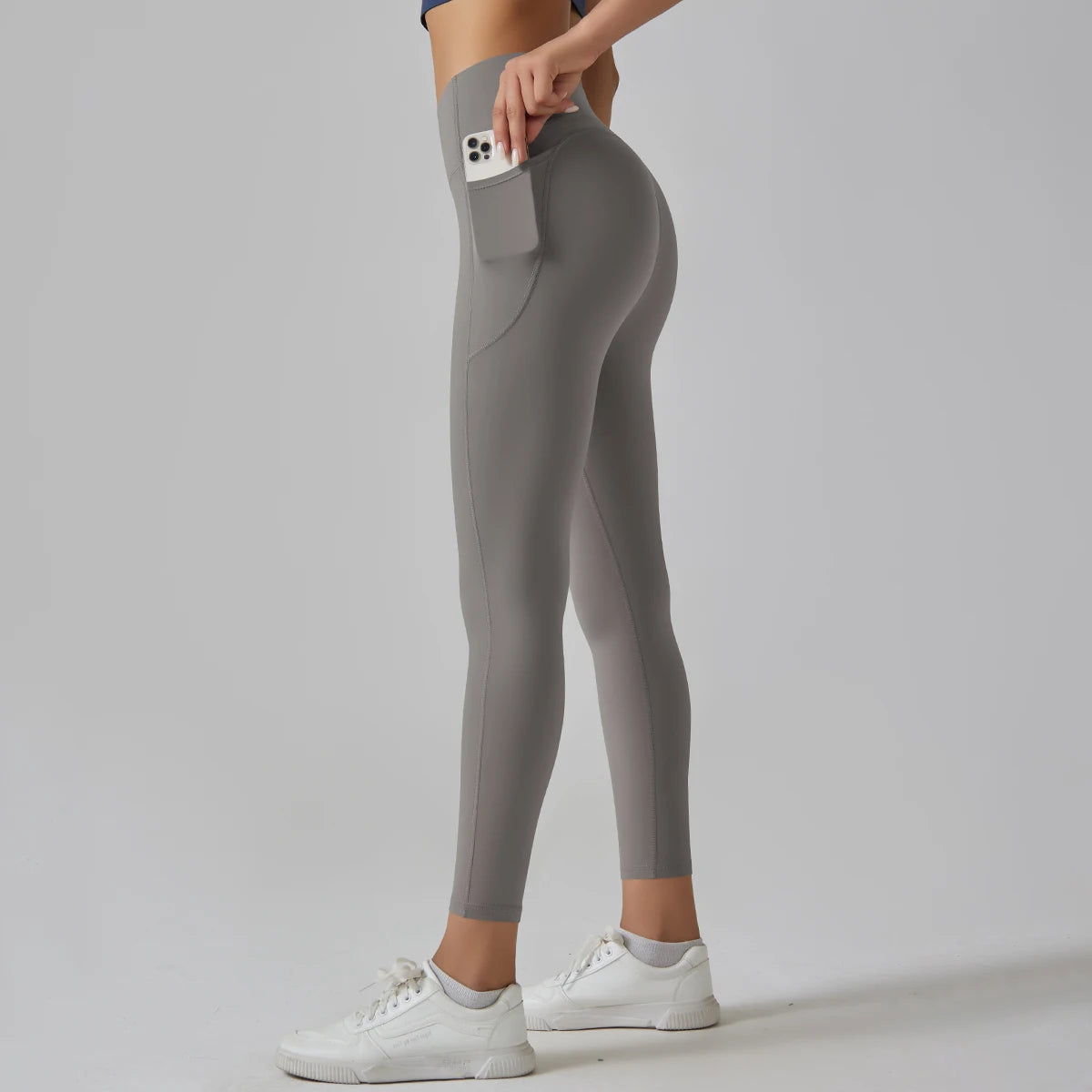 Graue High-Waist-Leggings mit Tasche am Oberschenkel, seitliche Ansicht