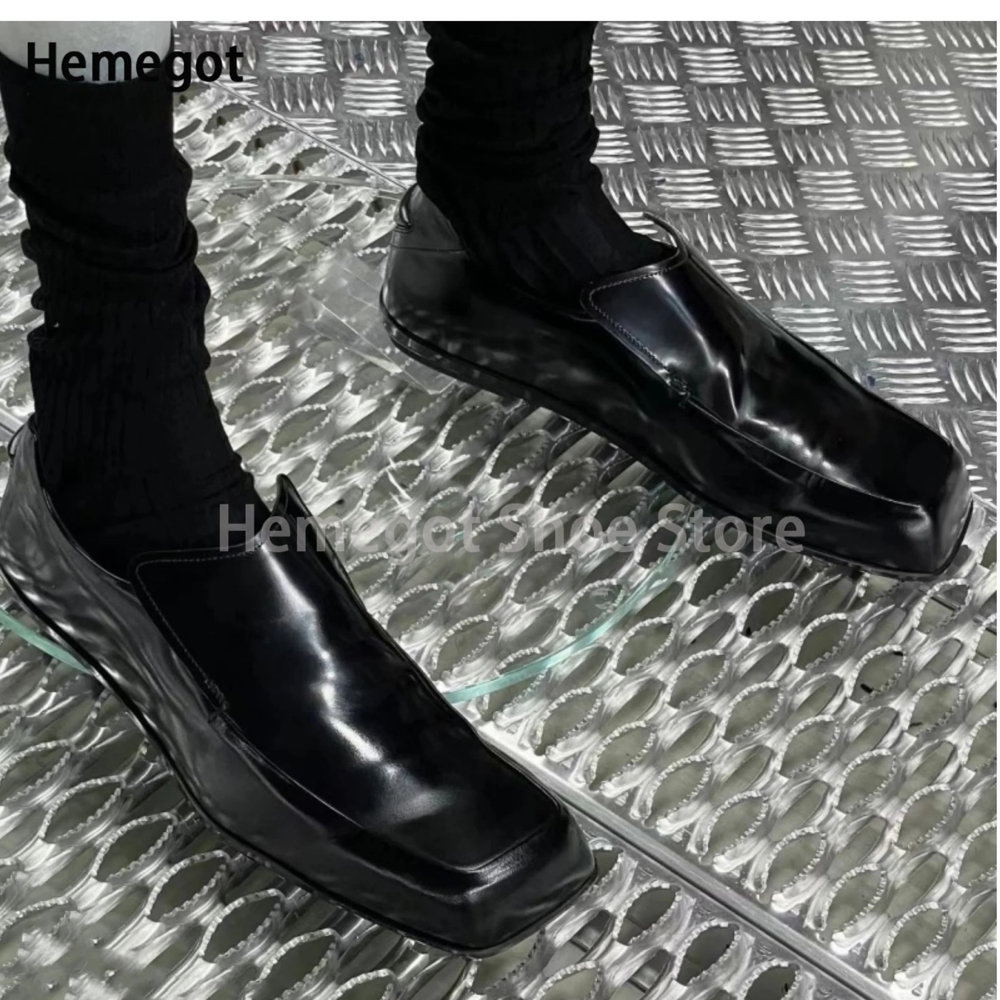 Schwarze Lederschuhe mit eckiger Spitze und flachem Slip-On, seitliche Ansicht.